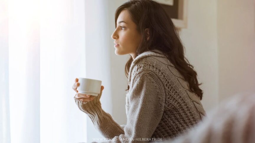 Nachdenkliche Frau am Fenster – negative Gefühle verstehen und einen neuen Umgang mit Emotionen finden